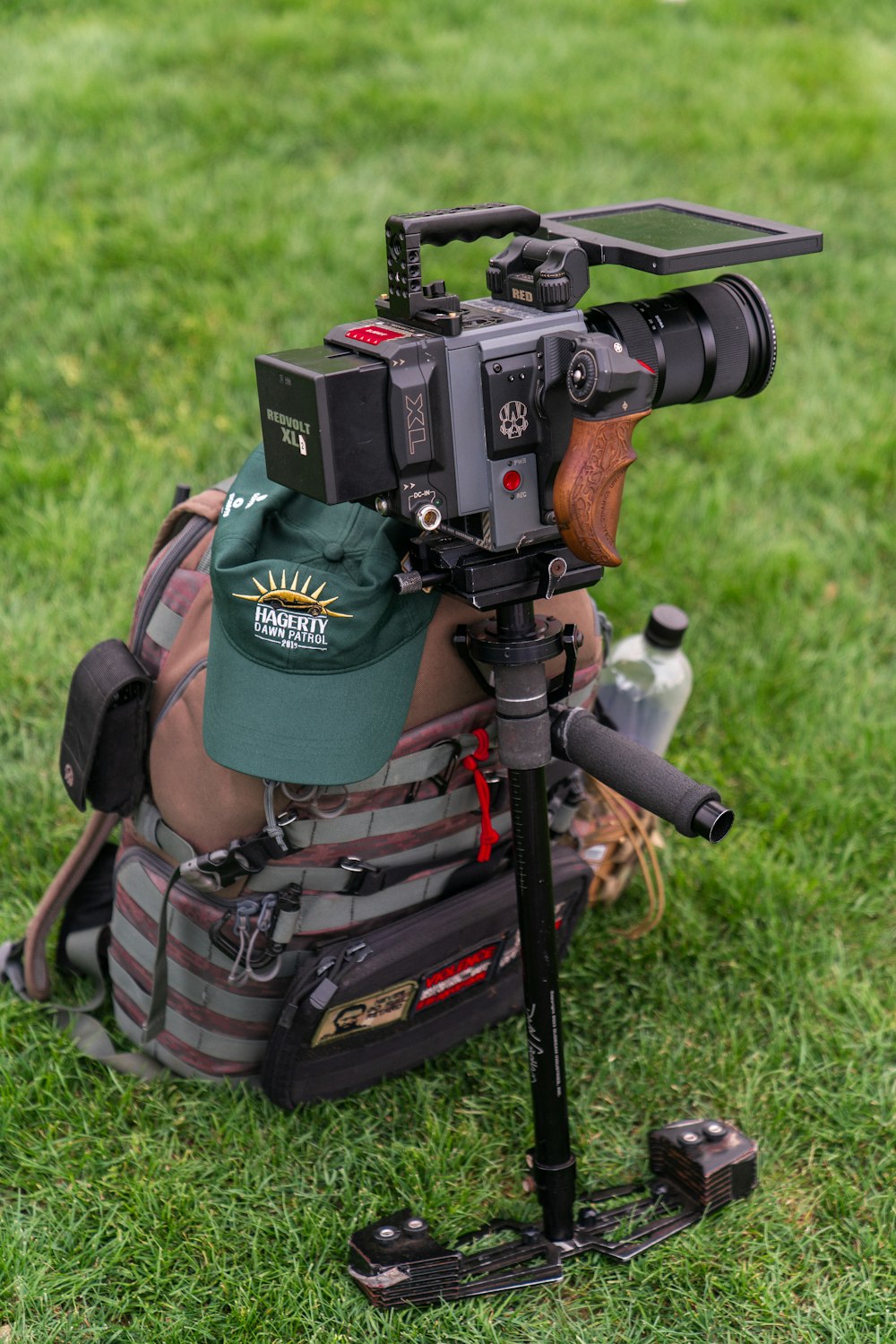 black professional camera besides brown backpack