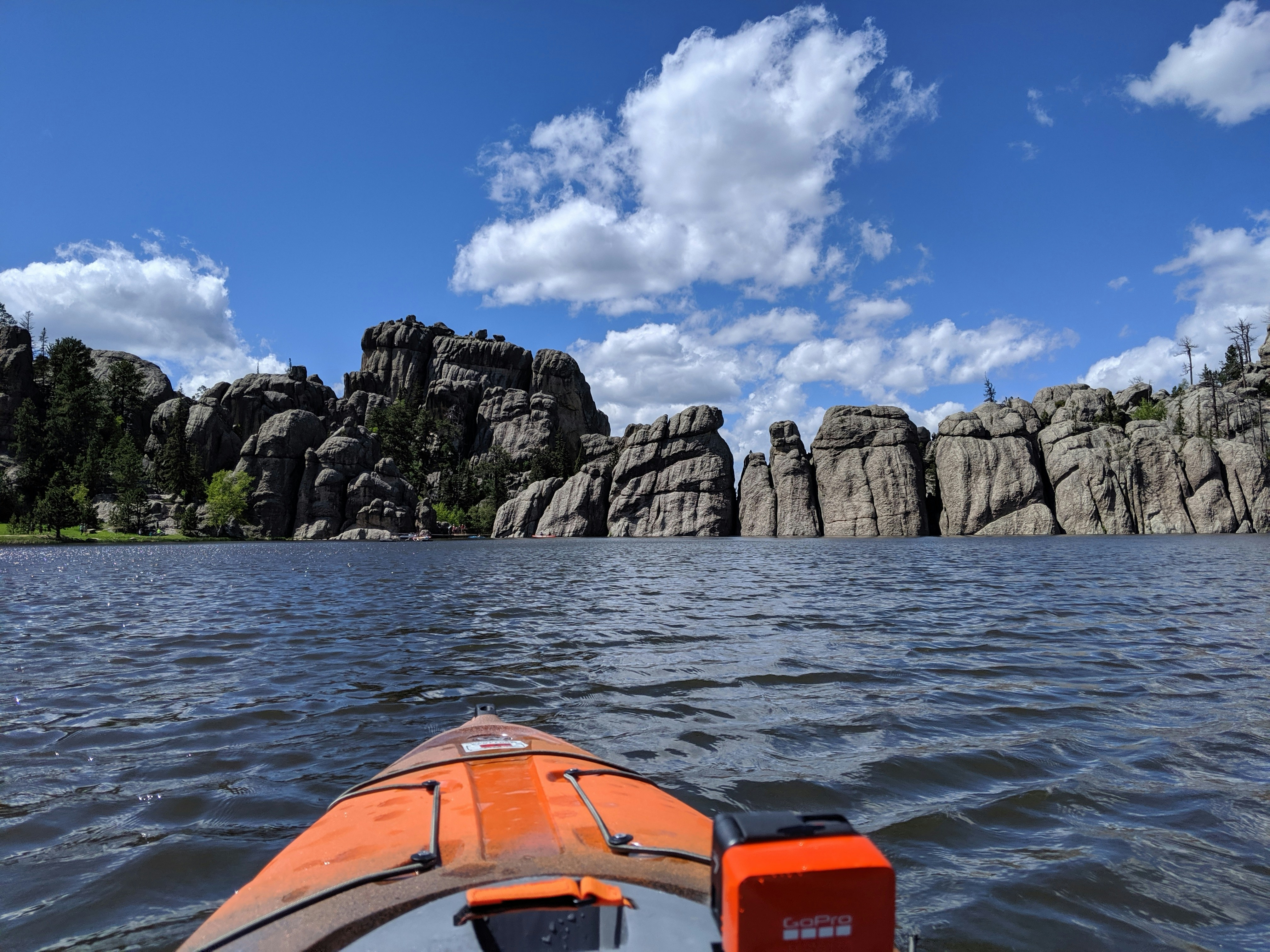 boat floating towards rocky island