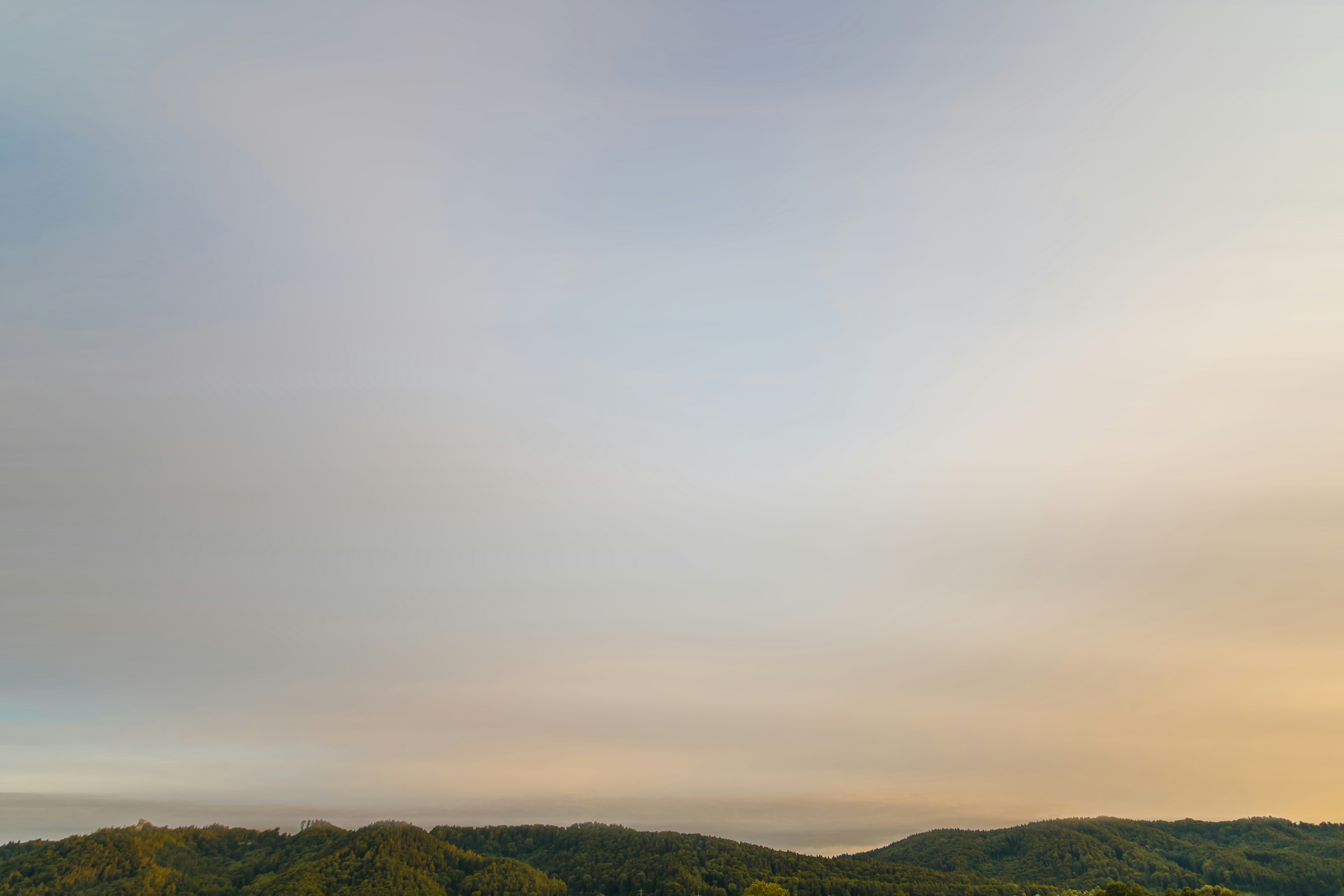 Expansive green Zimbabwe landscape at dawn, lush rolling hills, atmospheric morning mist, wild and serene