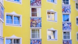 yellow building with paintings and windows