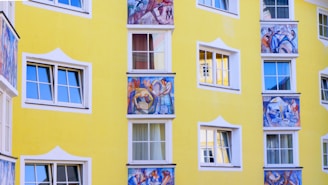 Brightly painted exterior facade with cheerful yellow and blue tones highlighting fresh plaster work.