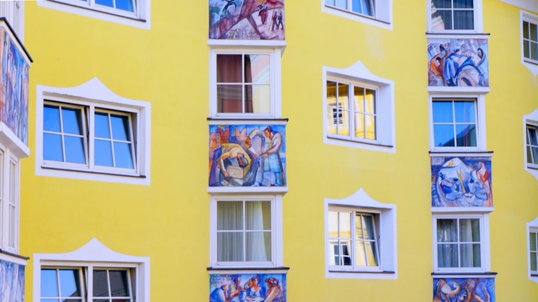 yellow building with paintings and windows