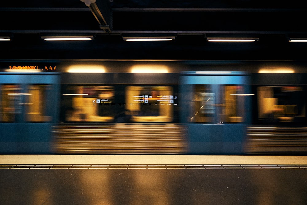 a train speeding past a train station next to a platform