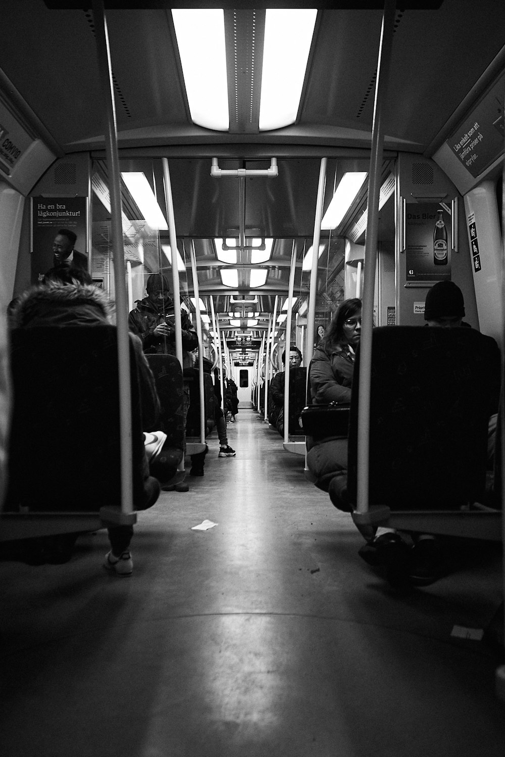 grayscale photo of woman sitting on train