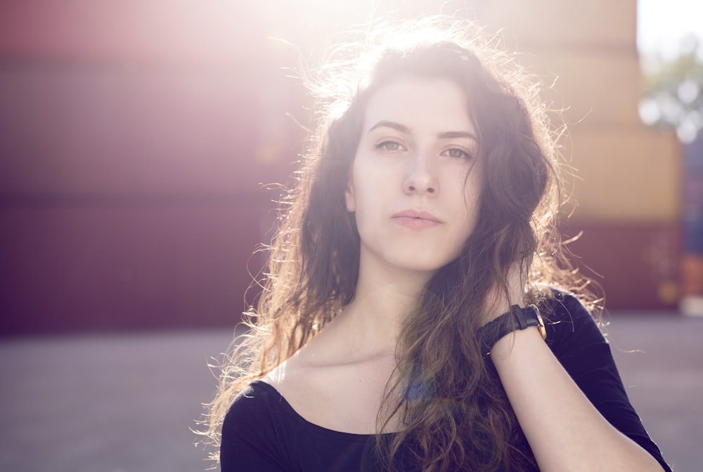 woman wearing black top holding hair