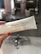 A person with red nail polish is holding a white tube labeled 'Double Phase Cleanser' by Beauty Pie. The background is a bathroom with a sink and blurred toiletries.