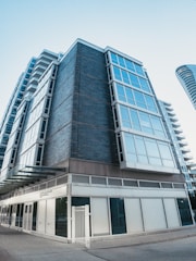 A commercial building exterior with clean brick walls and a spotless concrete walkway.