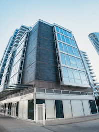 Modern commercial building with large glass windows and storefronts.