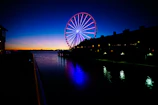 Aerial view of FG Big Wheel at sunset with neon blue lights glowing.
