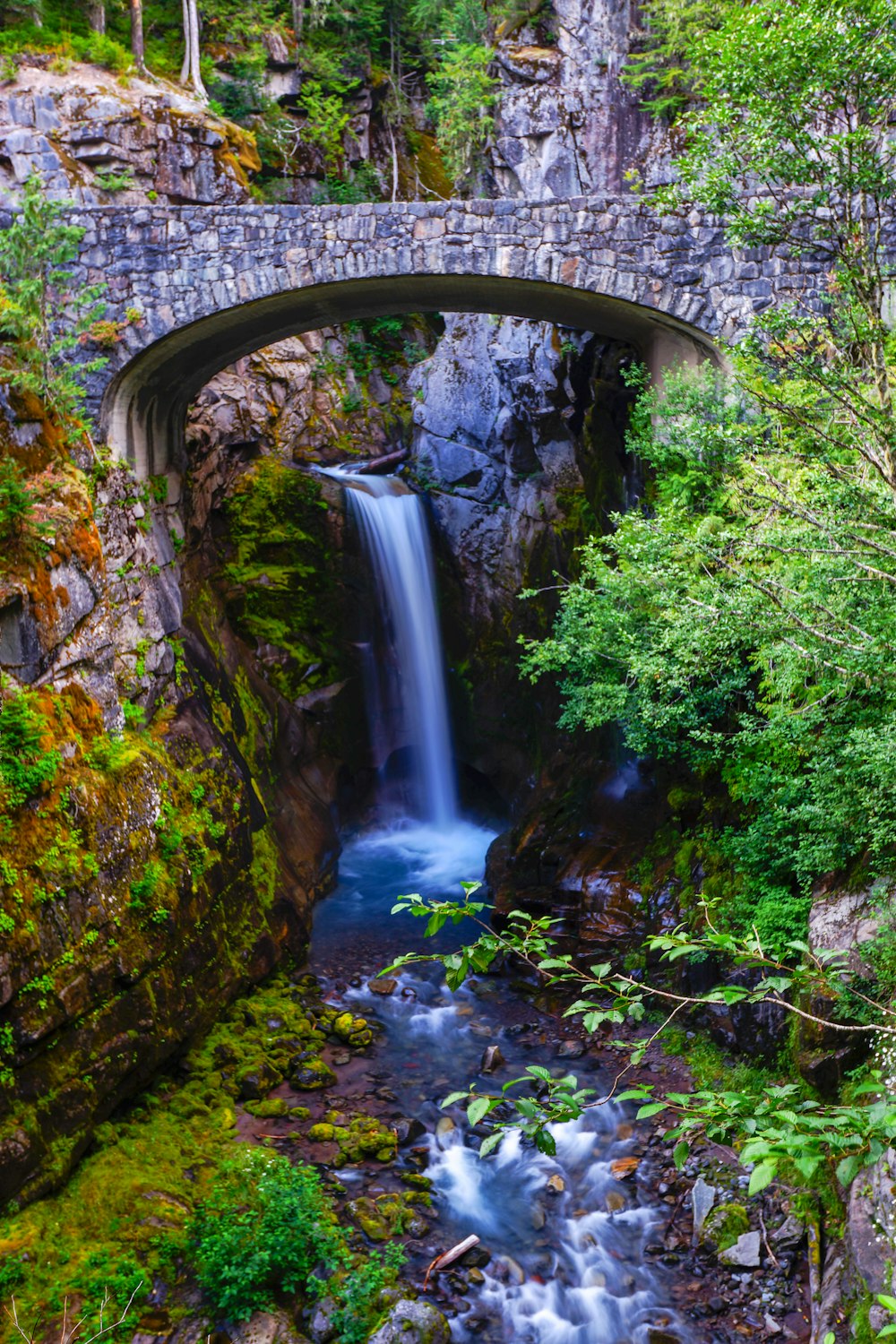 waterfall under stone bridge