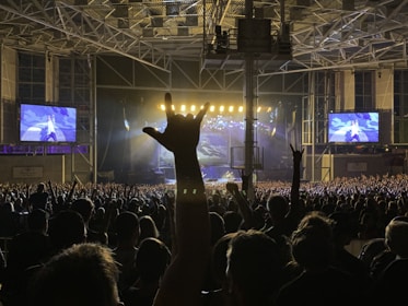 A panoramic view of a packed venue with fans cheering as Stayway plays a legendary rock anthem.