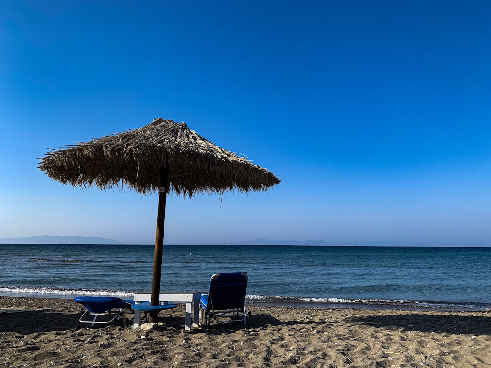 a straw umbrella and chairs on a beach