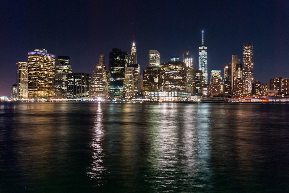 panoramic photo of lighted cityscape at night facing ocean