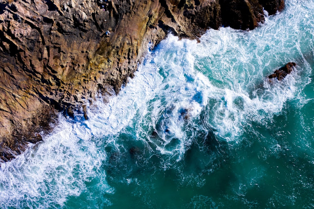 an aerial view of the ocean and rocks