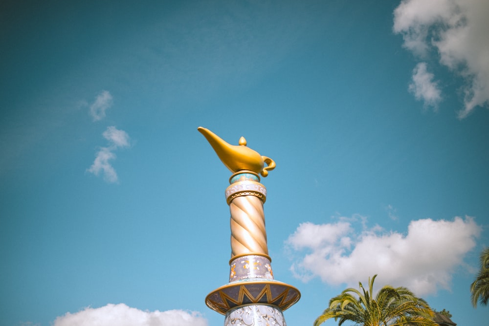 a gold and white statue of a fish on top of a fountain