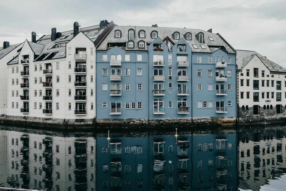 a row of buildings sitting next to a body of water