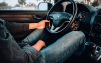 person holding black Honda car steering wheel