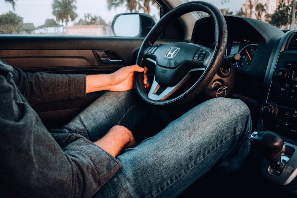 person holding black Honda car steering wheel