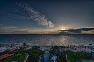 A serene Costa Rican beachfront property surrounded by lush greenery at sunset