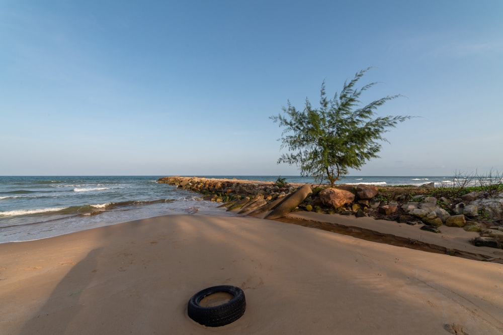 Ein Reifen, der an einem Strand neben dem Meer liegt