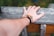 A person wearing a stylish bracelet made of colorful beads against a lively outdoor backdrop.