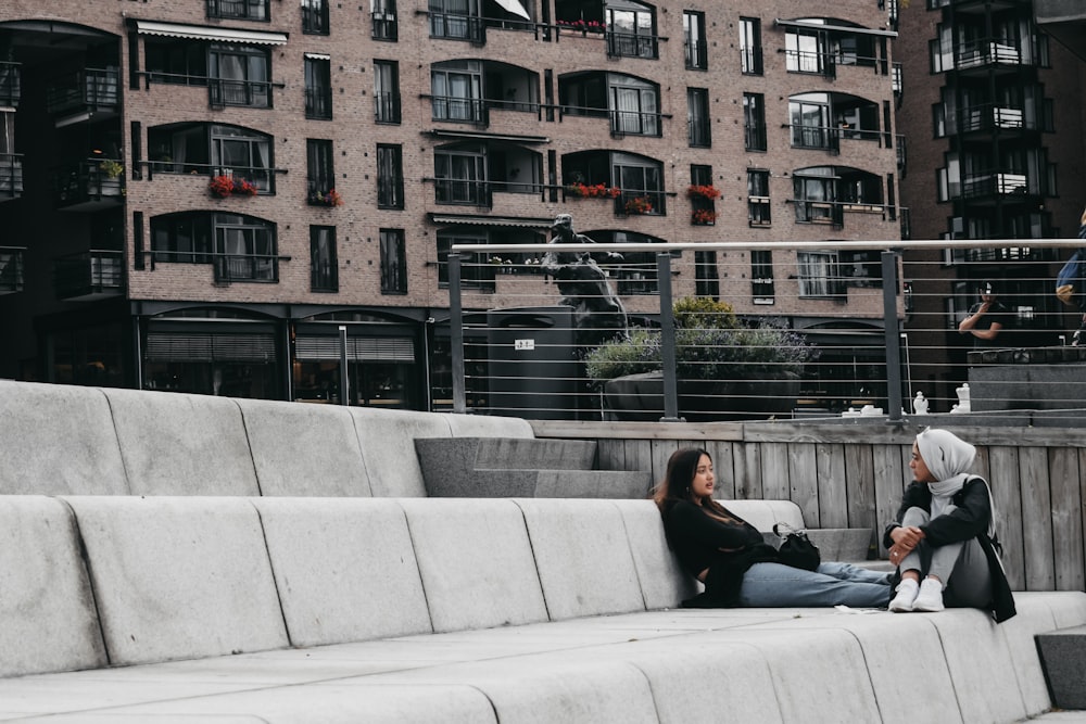 two women sitting near outdoor during daytime