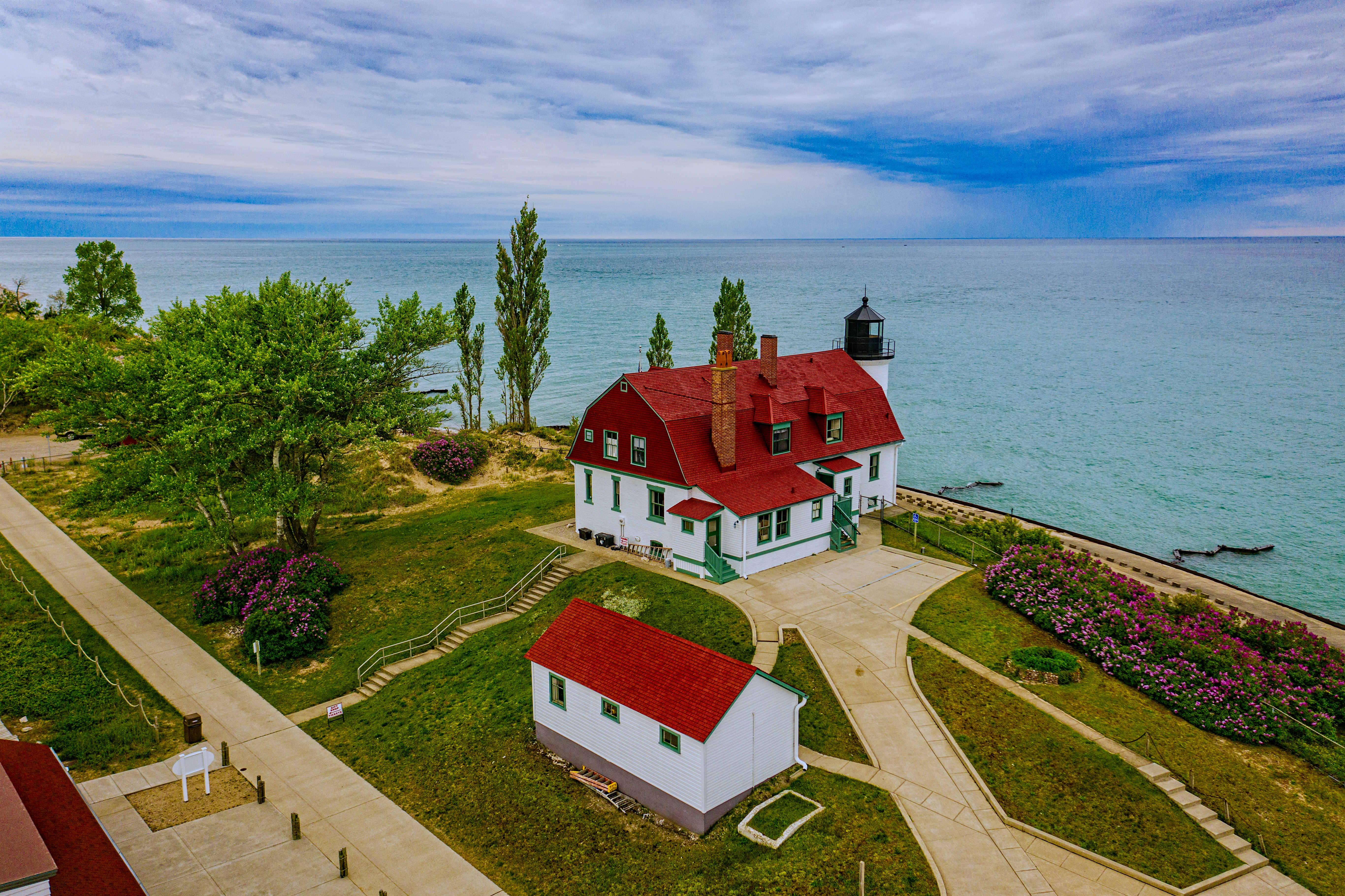 red and white concrete house near body of water under blue sky