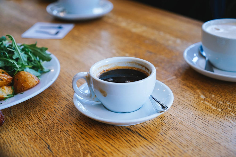 a cup of coffee and a plate of food on a table