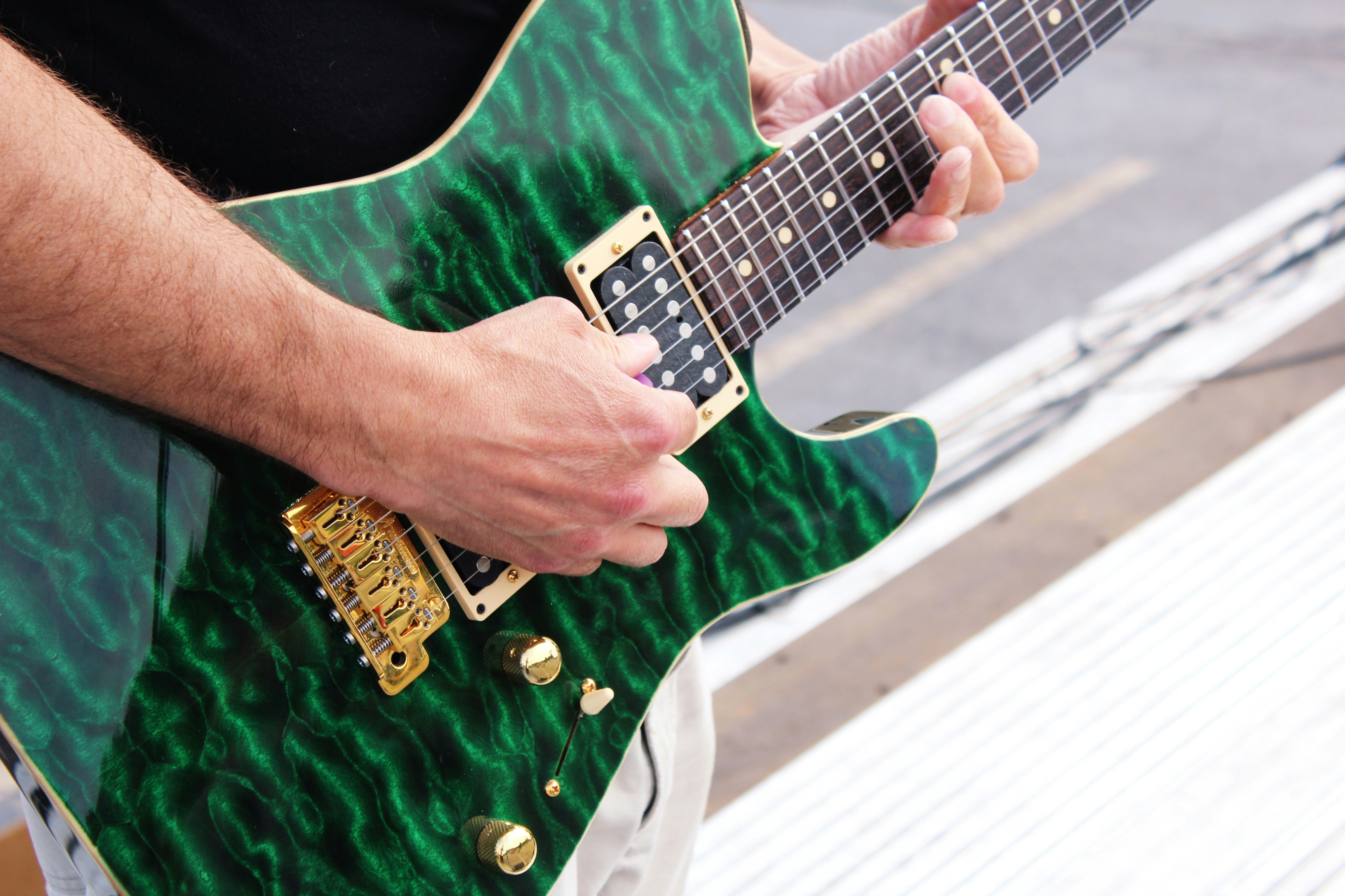 Man playing a green Tom Anderson electric guitar