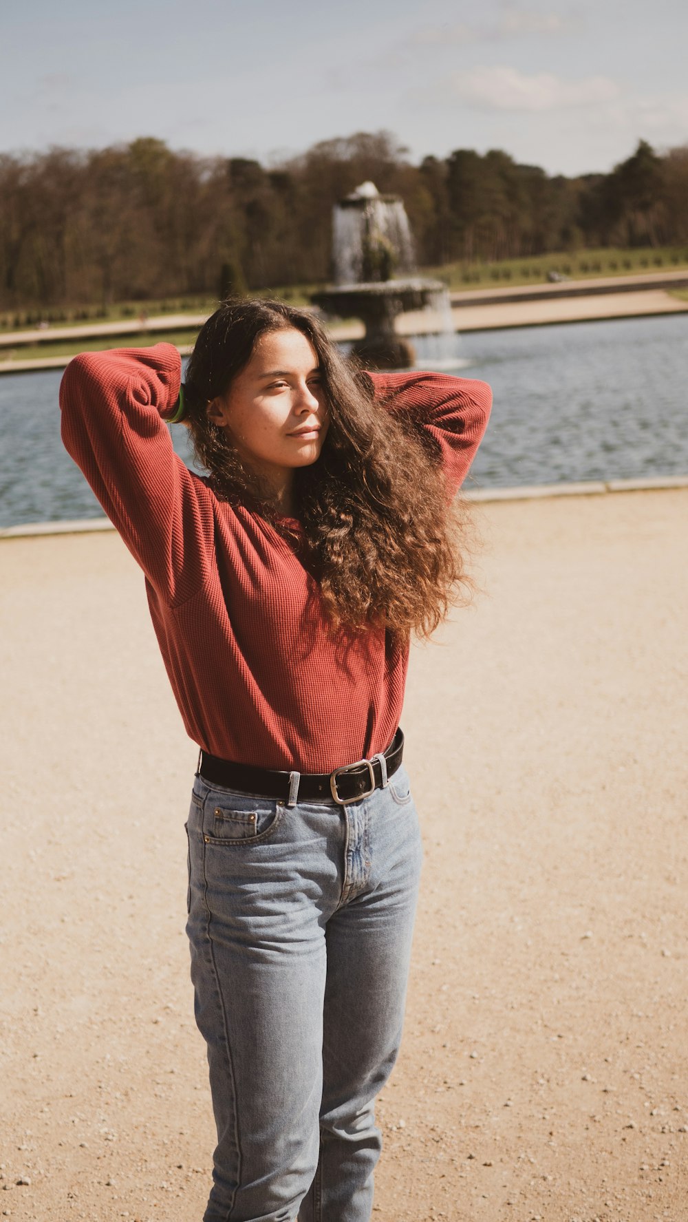 woman wearing red sweater near body of water