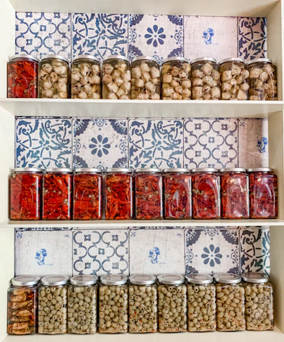 Close-up of colorful homemade canned jars neatly arranged on a rustic wooden shelf