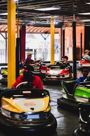 a group of people riding bumper cars inside of a building