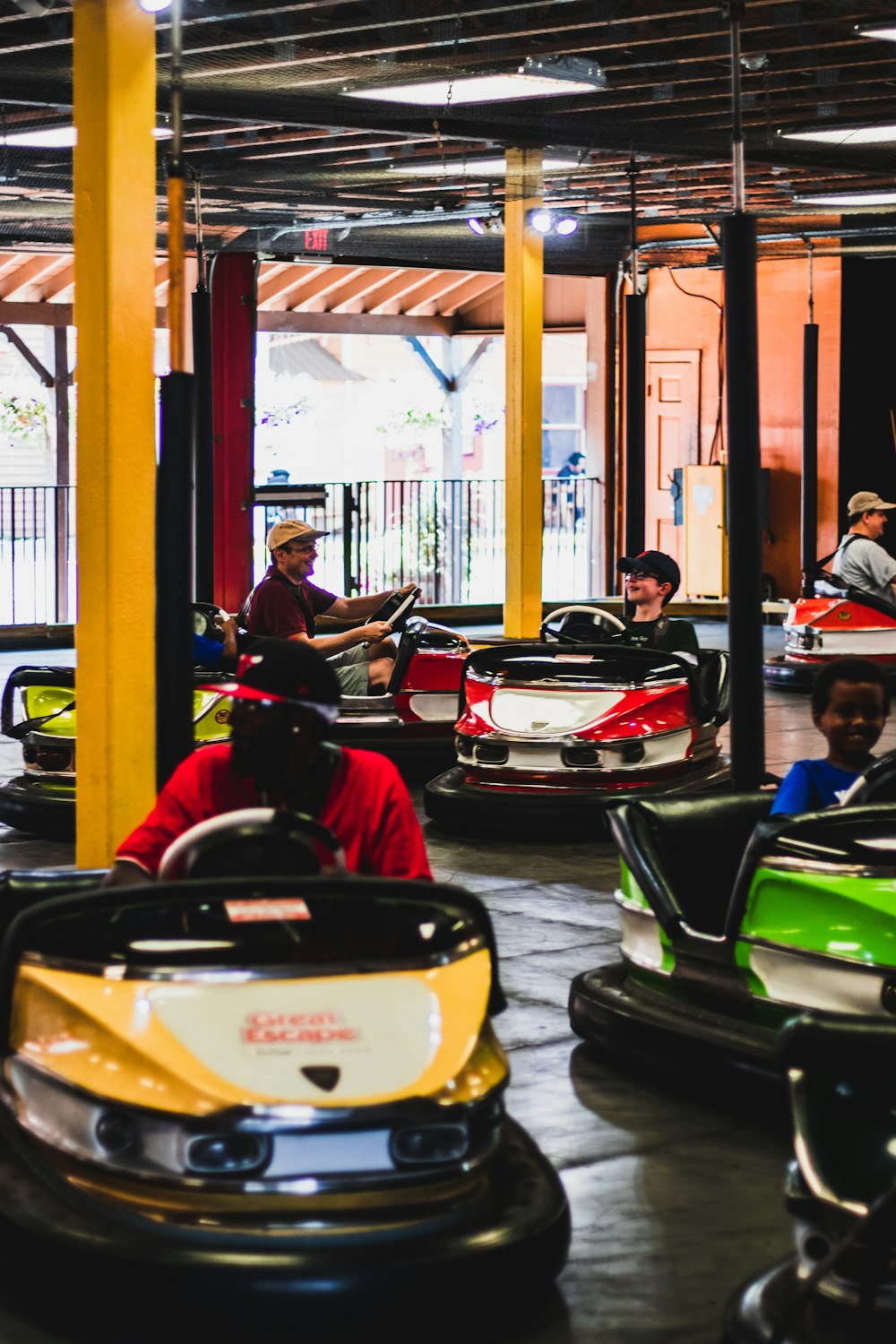 a group of people riding bumper cars inside of a building