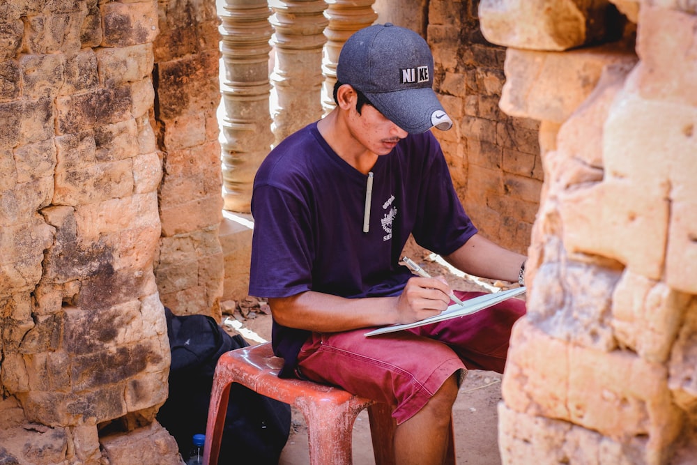 man writing on paper