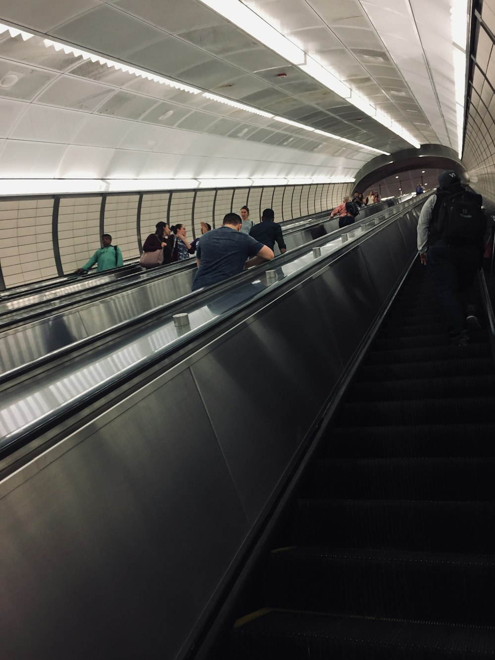 a group of people riding down an escalator