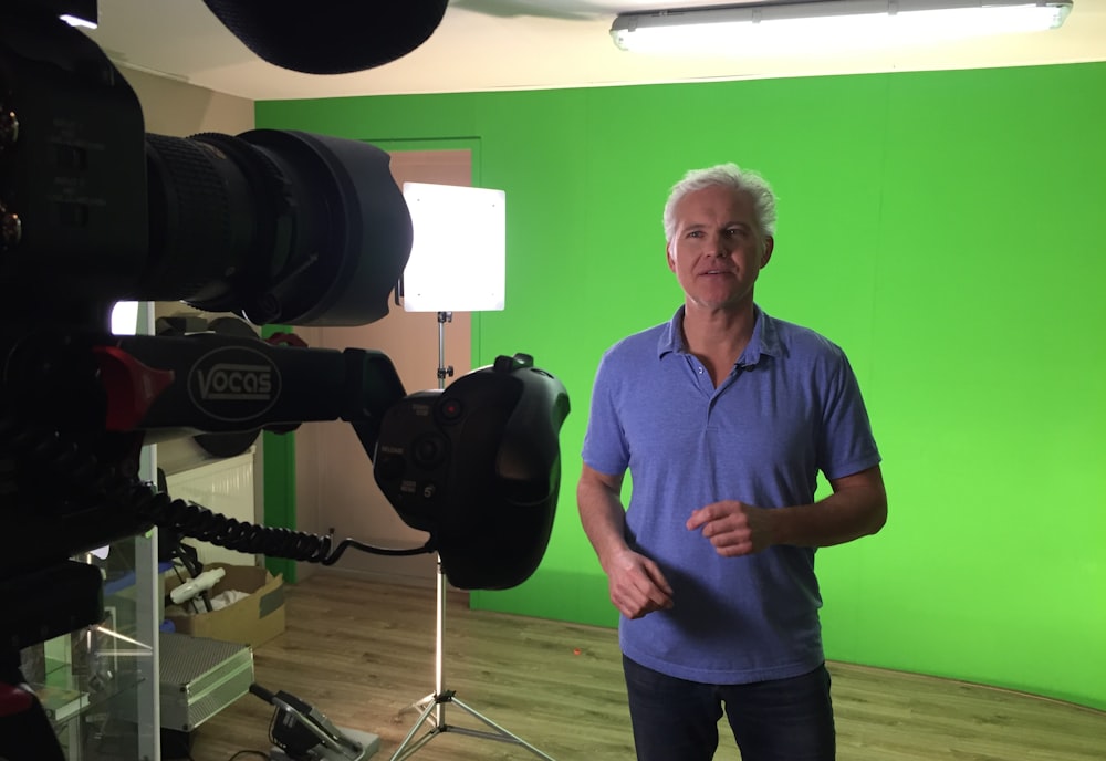 man standing against green wall