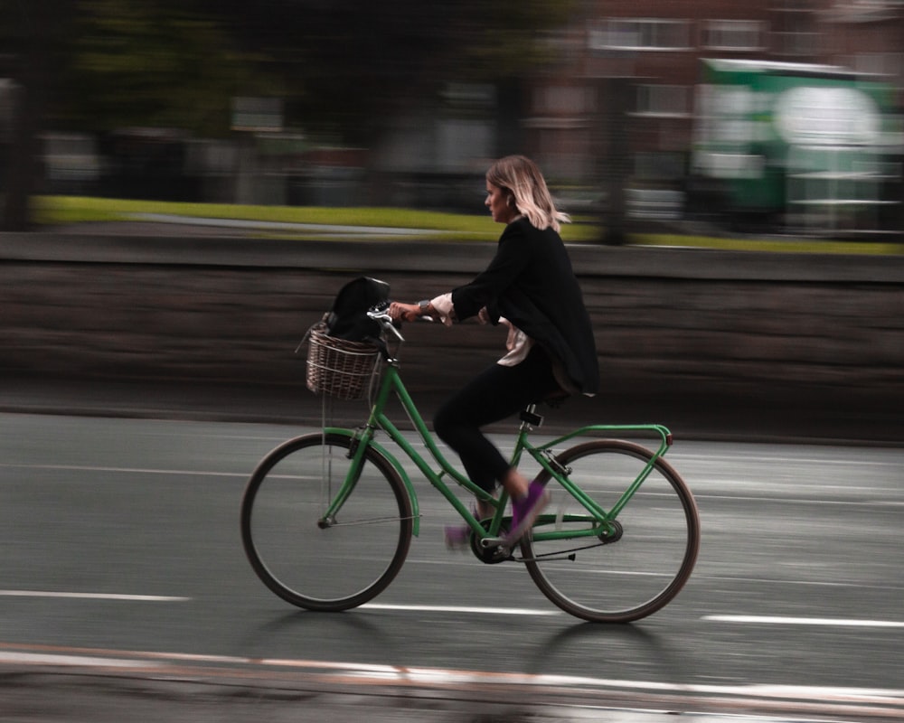 woman riding green commuter bike with brown basket