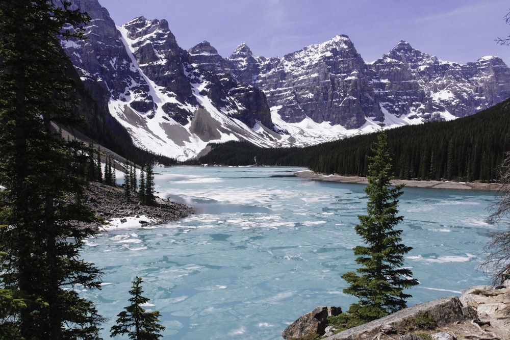 body of water near snow-covered mountain