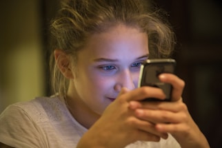 A young person writing a message on a smartphone.
