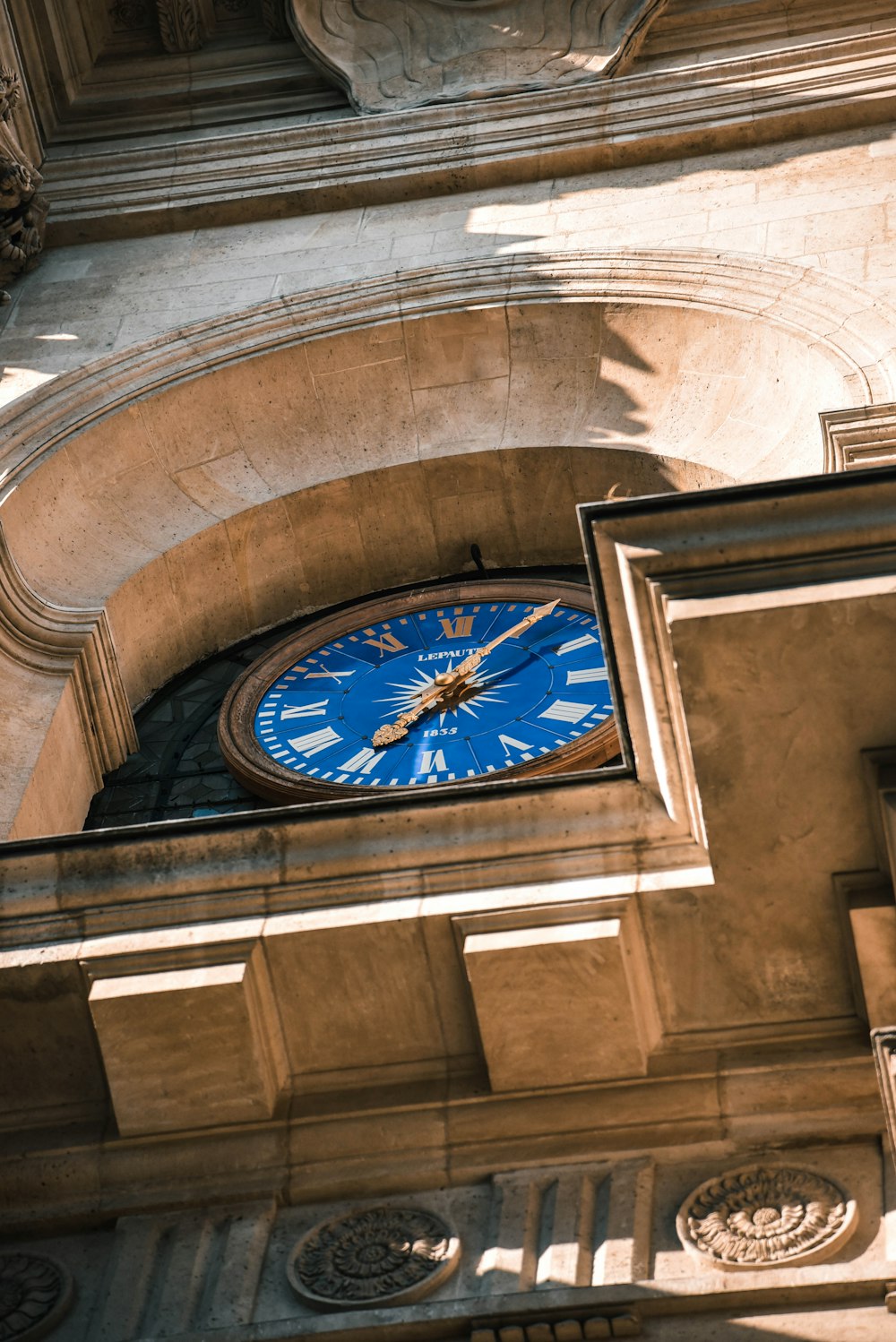 a large blue clock mounted to the side of a building