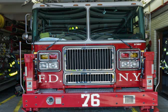 Firefighter arriving swiftly at a Brooklyn home with emergency gear.
