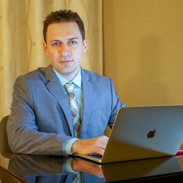 man sits in front of laptop computer