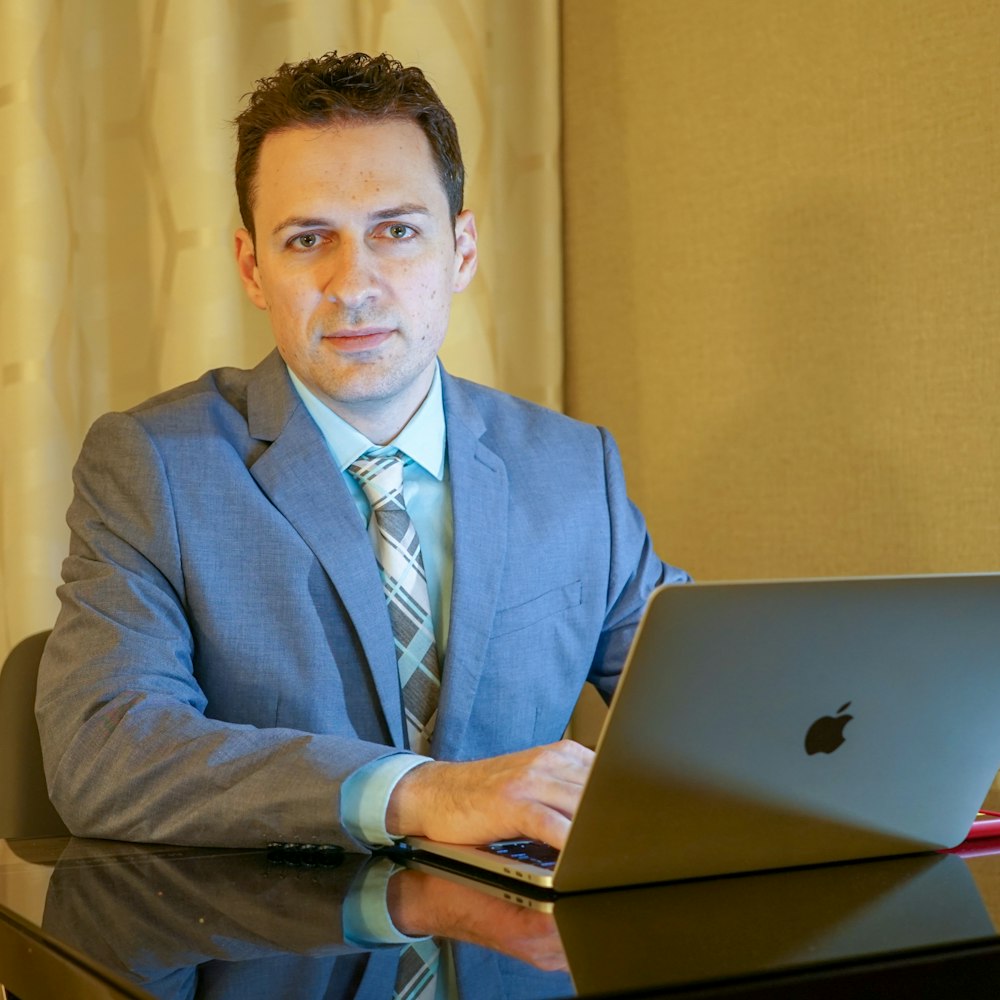 man sits in front of laptop computer