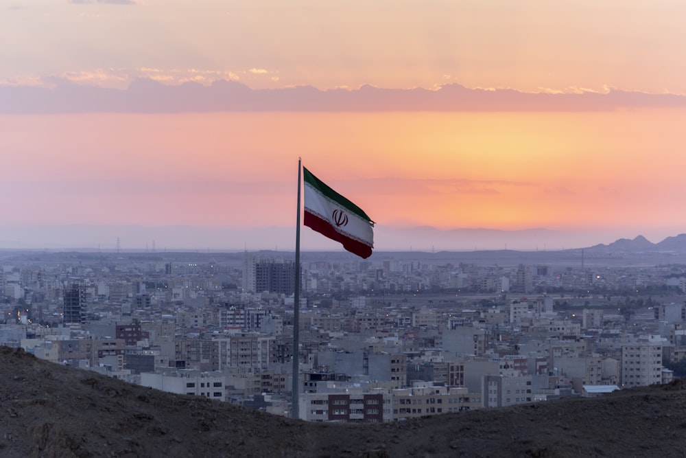 flag on pole near the city during day