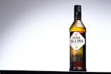 A bottle of Vana Tallinn is centered against a gradient background, transitioning from dark to light gray. The bottle has a textured cap and label detailing the brand and alcohol content, marked as 40. The design is classic with a focus on elegance and simplicity.