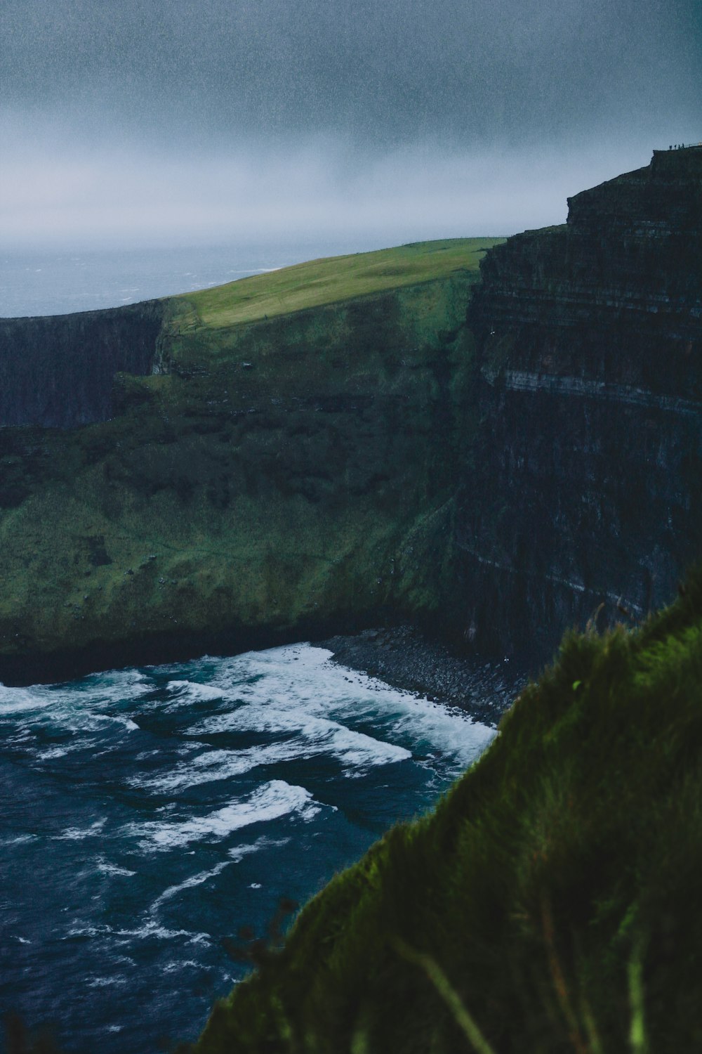 grassy cliff under gray sky