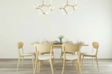 Mid-century teak dining chairs arranged neatly around a minimalist dining table in a bright room.