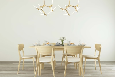 A stylish dining table set with neutral-toned tableware and minimalist centerpiece in a bright room.