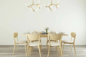 Mid-century teak dining chairs arranged neatly around a minimalist dining table in a bright room.