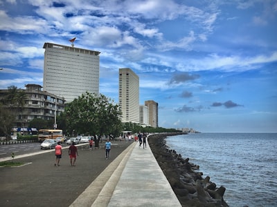 people walking on side walk beside beach mumbai zoom background